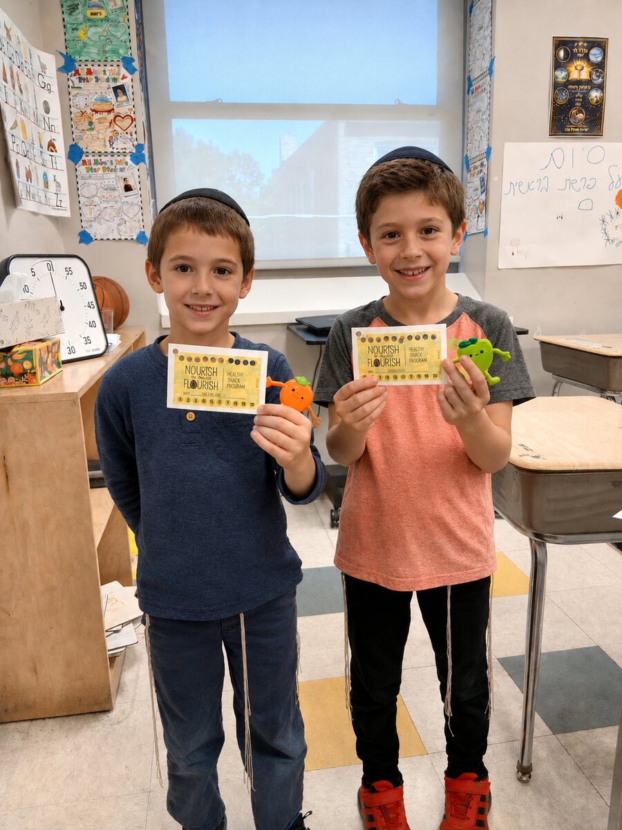 Two students holding their Nourish to Flourish Healthy Snack Program punch cards
